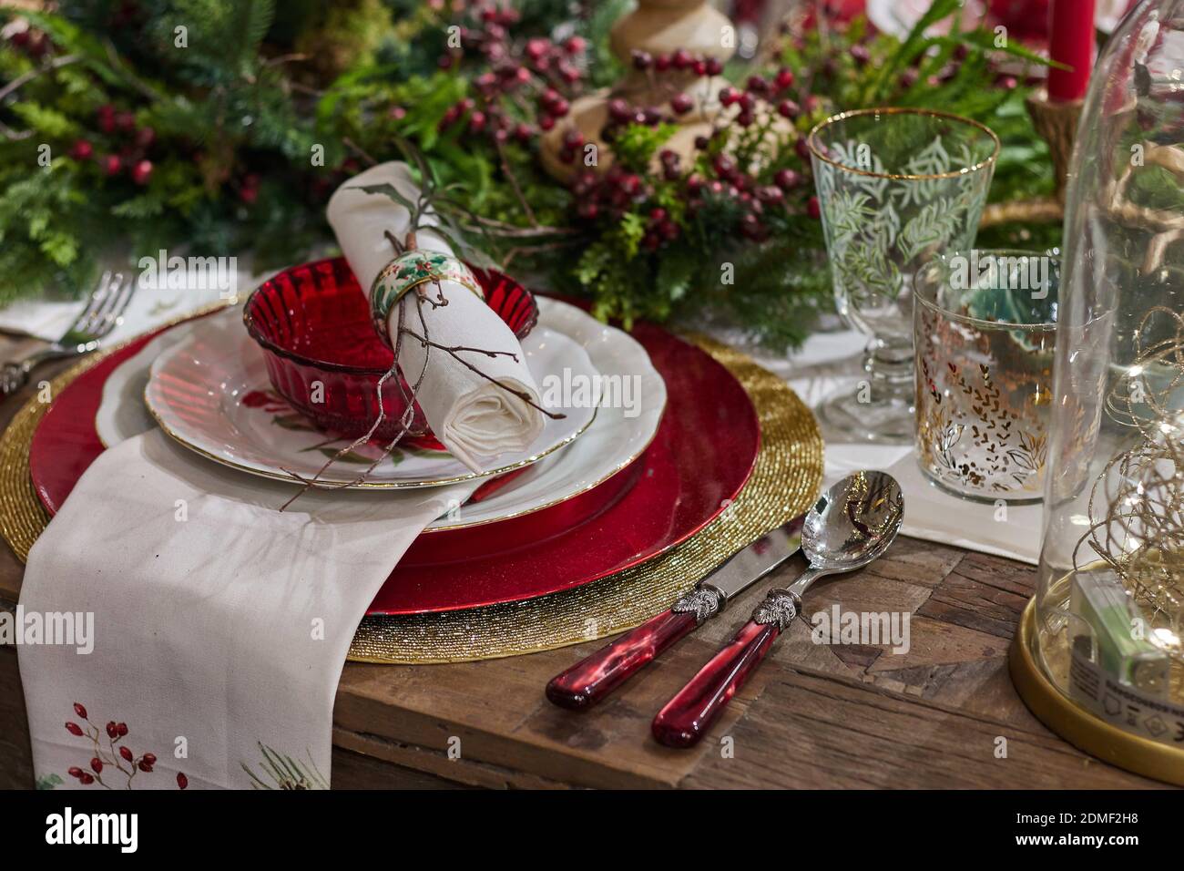 A high angle shot of Christmas dinner set up with glasses and ornaments