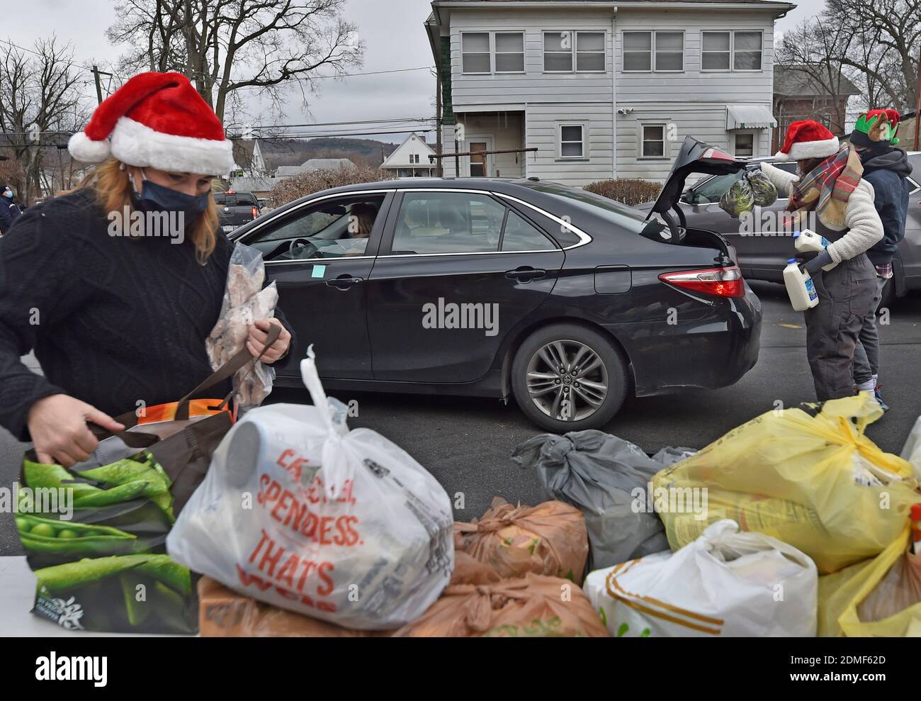 Kingston, United States. 16th Dec, 2020. Volunteers fill cars with food at a drive thru food bank.Since the start of Covid the Al Beech food pantry has been very busy, today they served there one millionth guest. For Christmas volunteers wore Santa hats and handed out gift cards, candy and balloons along with the regular food goods. Credit: SOPA Images Limited/Alamy Live News Stock Photo