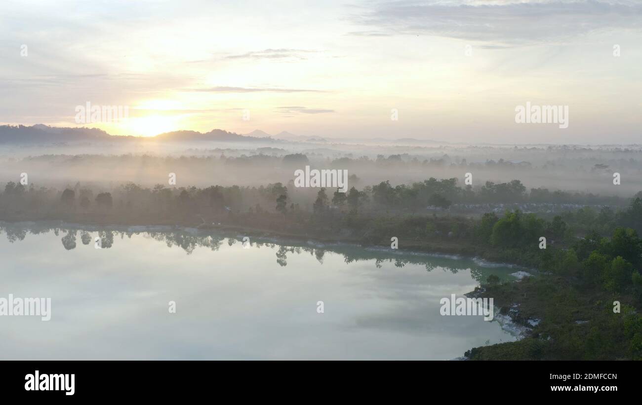 An aerial shot of the foggy forest landscape during the sunset Stock ...