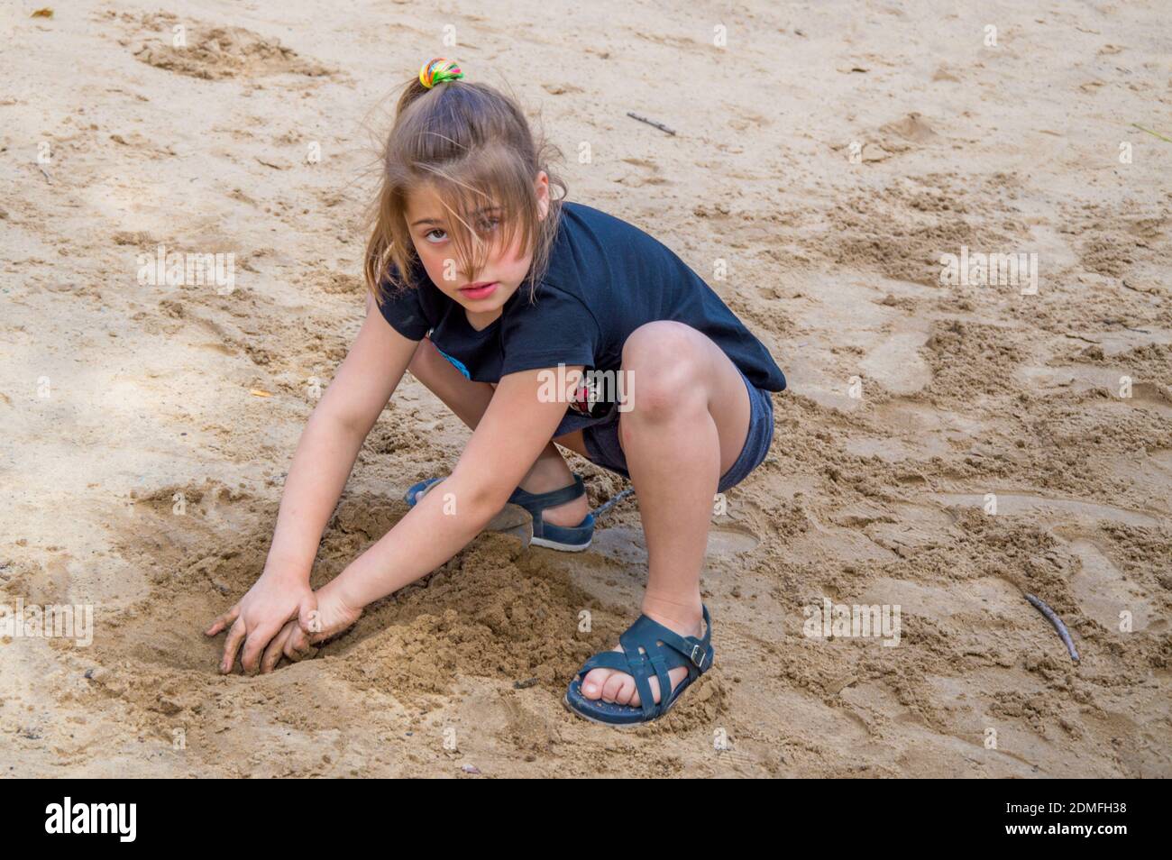 Portrait Of Girl Playing On Sandy Beach Stock Photo
