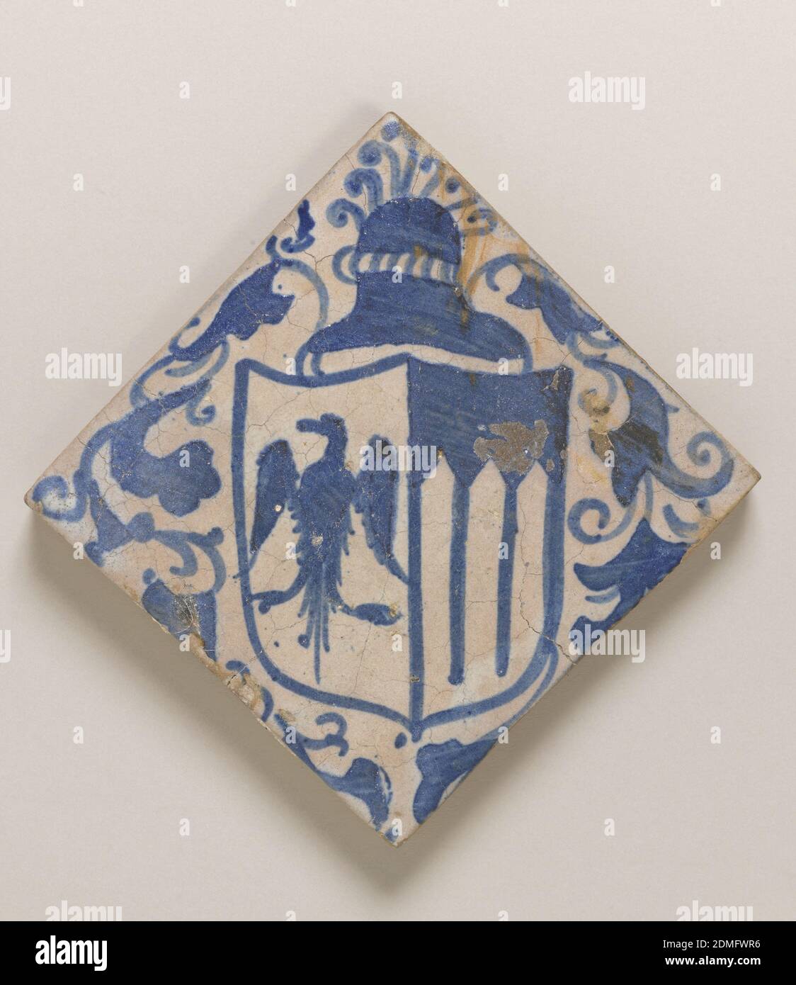 Floor tile, Glazed and painted earthenware, Square tile of buff clay with  thin underfired opaque grayish-white glaze. Underglaze blue painting of  diagonally placed heraldic shield with eagle and three pointed arches.  Above,