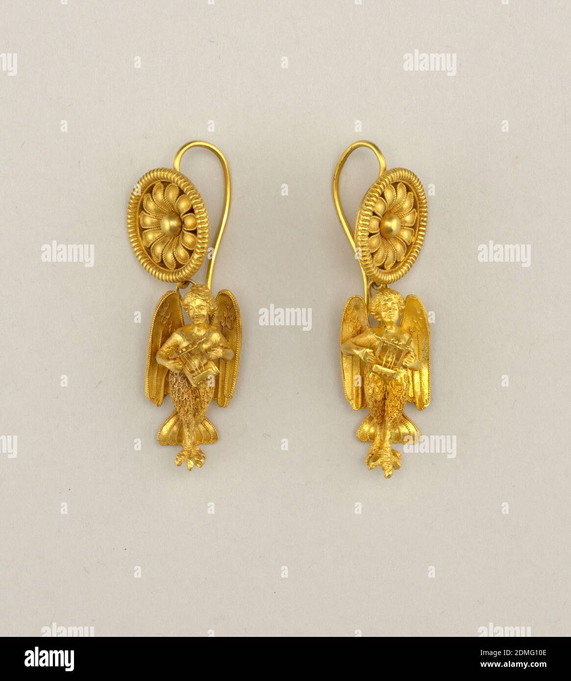 Siren Earrings, Gold, Each earring with circular ornament in open-daisy design from which hangs a fantastic figure (head and upper body, human with wings and feet of a bird)., Rome, Italy, ca. 1870, jewelry, Decorative Arts, Pair of earrings, Pair of earrings Stock Photo