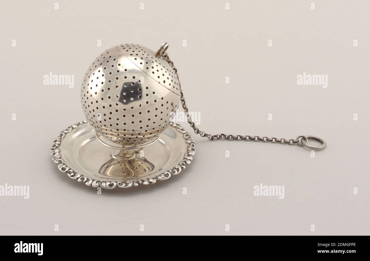 Tea Infuser with Stand, silver, Orb-shaped infuser with chain; stand with wire work support on circular dish with scroll border., New York, New York, USA, ca. 1900, metalwork, Decorative Arts, tea infuser, tea infuser Stock Photo