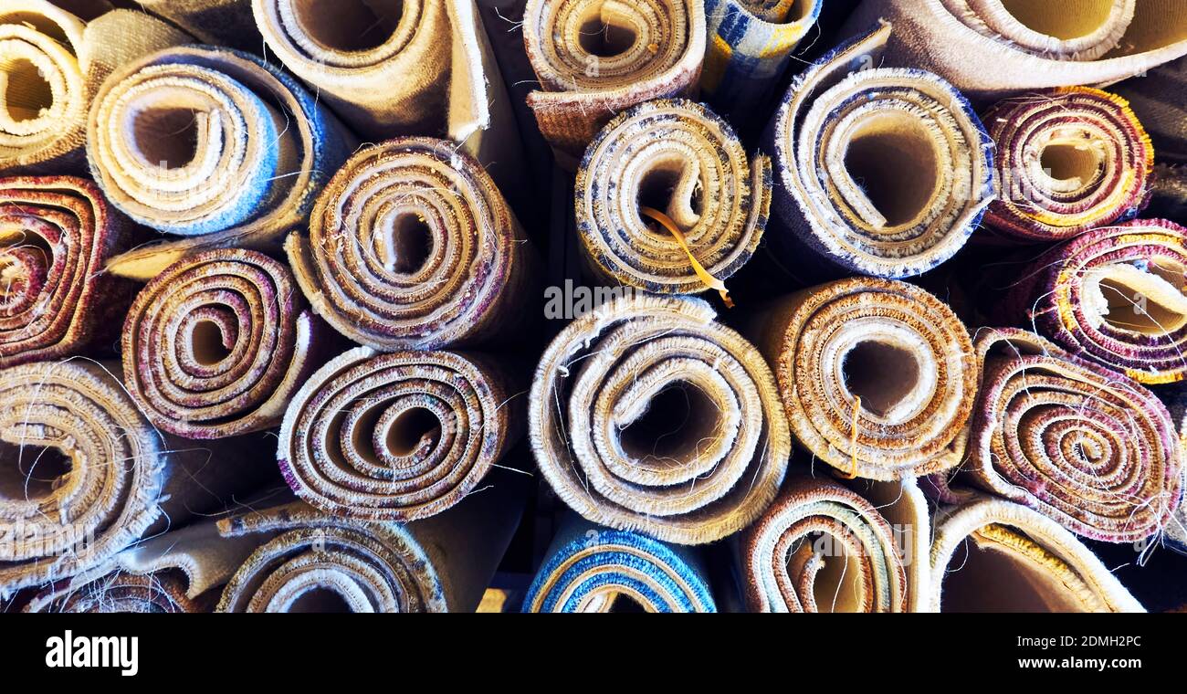 Variety of colorful carpets rolled up for display in a warehouse carpet