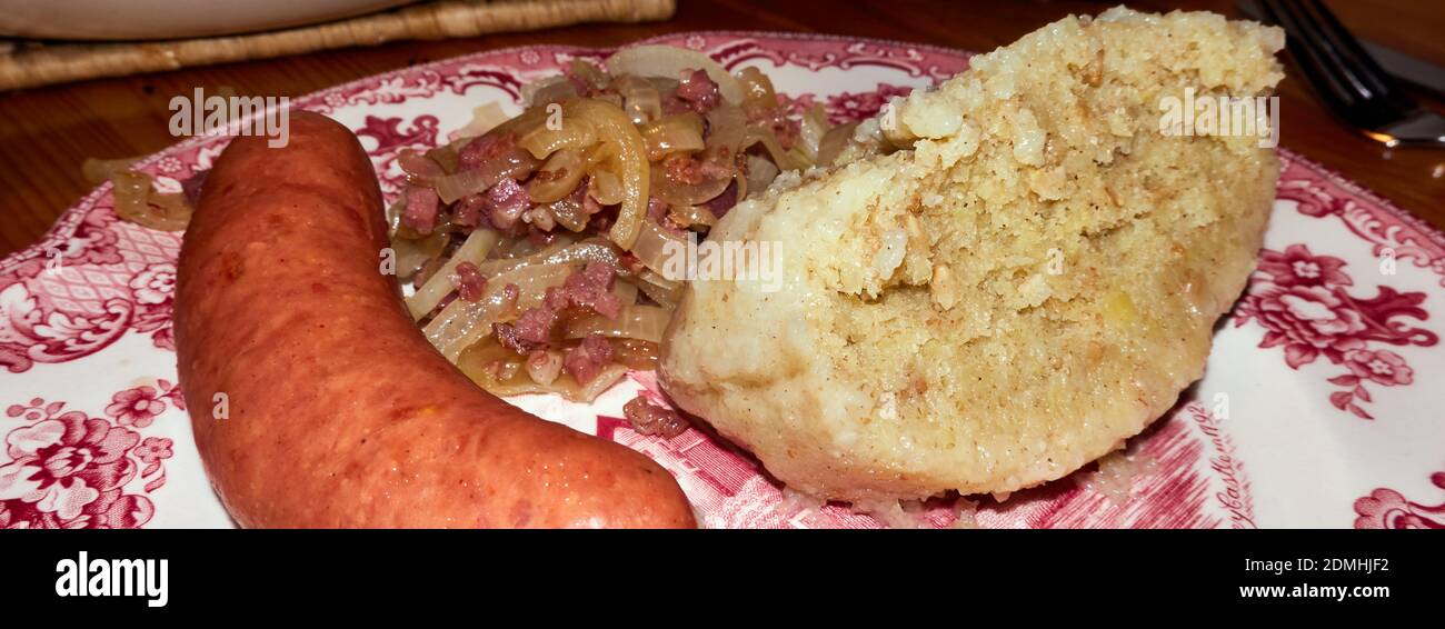 Potato dumpling, onions with bacon and fat sausage, German traditional
