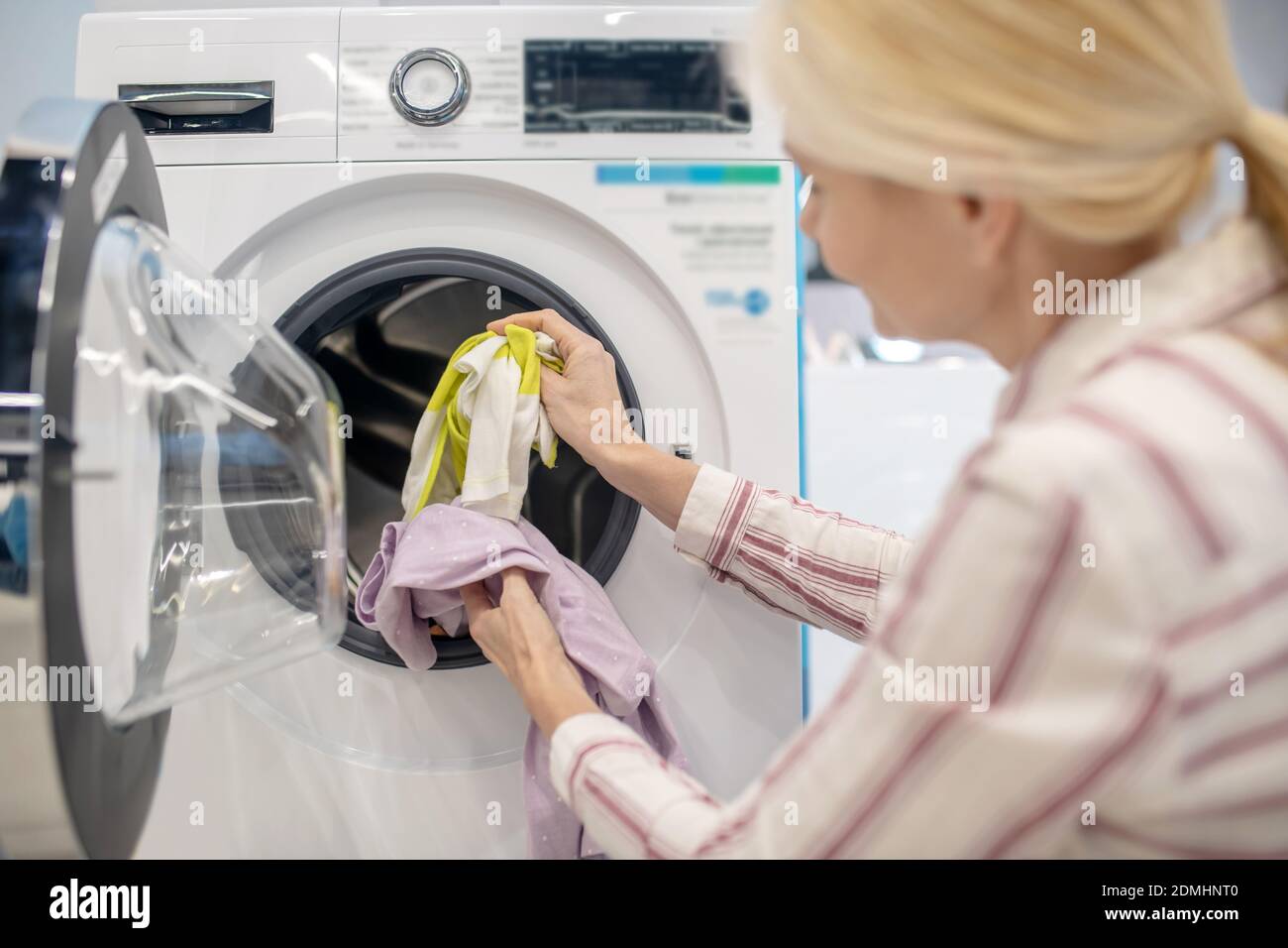 Female housewife putting clothes into washing machine Stock Photo Alamy