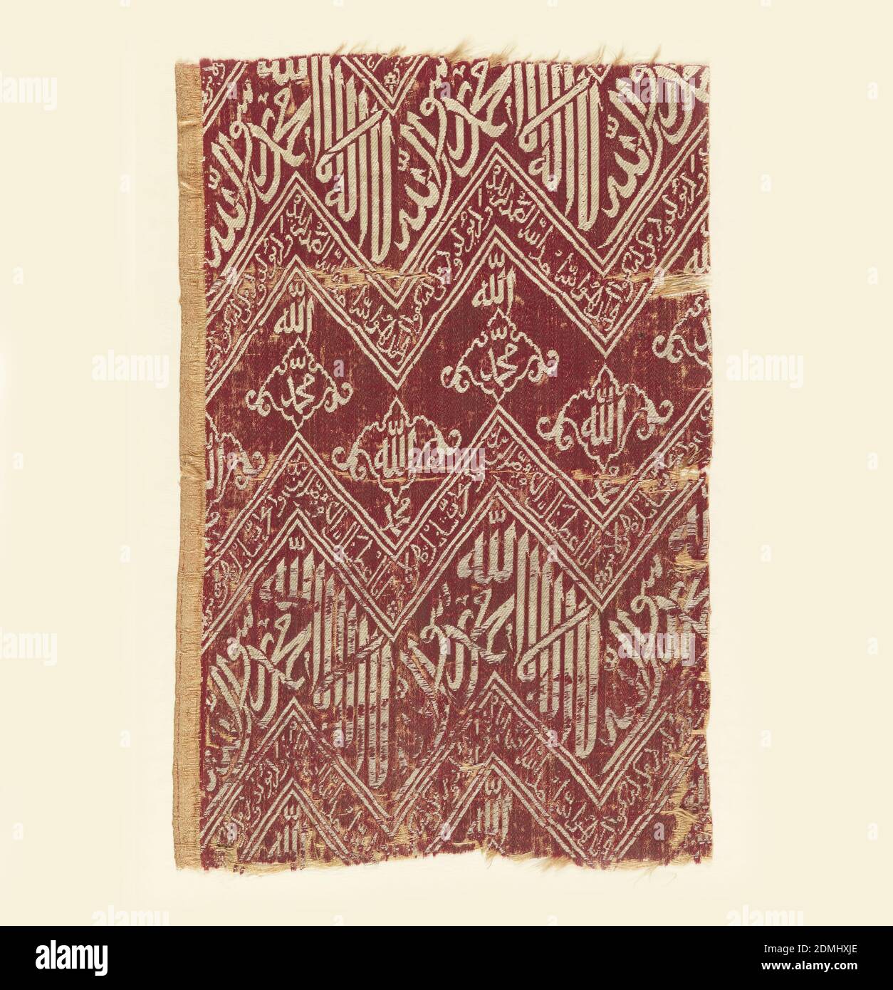 Textile, Medium: silk Technique: compound satin Label: silk compound satin, Fragment of woven silk with zigzag bands of Kufic script in white on a red ground. The inscriptions are translated as (top to bottom):, There is no god but Allah, Muhammad is the prophet of God (repeated), Say: He is God alone: God the Eternal! He begetteth not and is not begotten; and there is none like unto him, Allah (repeated) Muhammad (repeated), Truly we have given thee an abundance; Pray therefore to the Lord, and slay the victims. Verily whoso hateth thee shall be childless, Turkey, 16th–17th century, woven Stock Photo