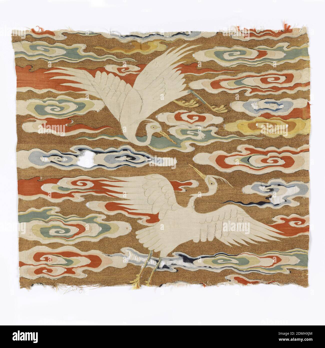 Rank badge, Medium: silk, metallic yarns Technique: plain weave with discontinuous wefts (tapestry or k'ossu), open slits, Most of a Ming dynasty Sixth Rank square showing a pair of egrets with spread wings arched across a gold sky filled with brightly colored attenuated cloud streamers. Birds are white with the characteristic slender head plume, yellow beak, feet and eyes, with pale green details. Cloud bands are white with shades of blue, pale green, yellow and vermillion on a gold metallic ground., China, Ming dynasty, 1368–1644, woven textiles, Rank badge Stock Photo