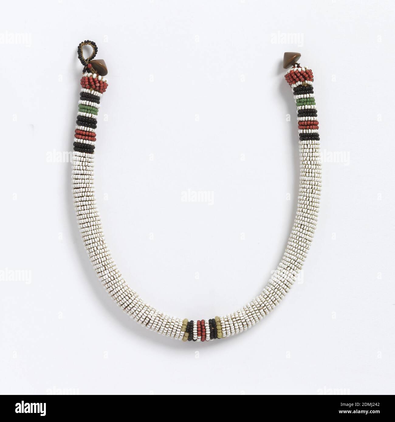 Necklace, Medium: glass beads, metal fasteners, Tubular necklace with horizontal rows of white glass beads, with red, green and black stripes at the center front and back. Cone-shaped metal fastener., South Africa, late 19th–early 20th century, jewelry, Necklace Stock Photo