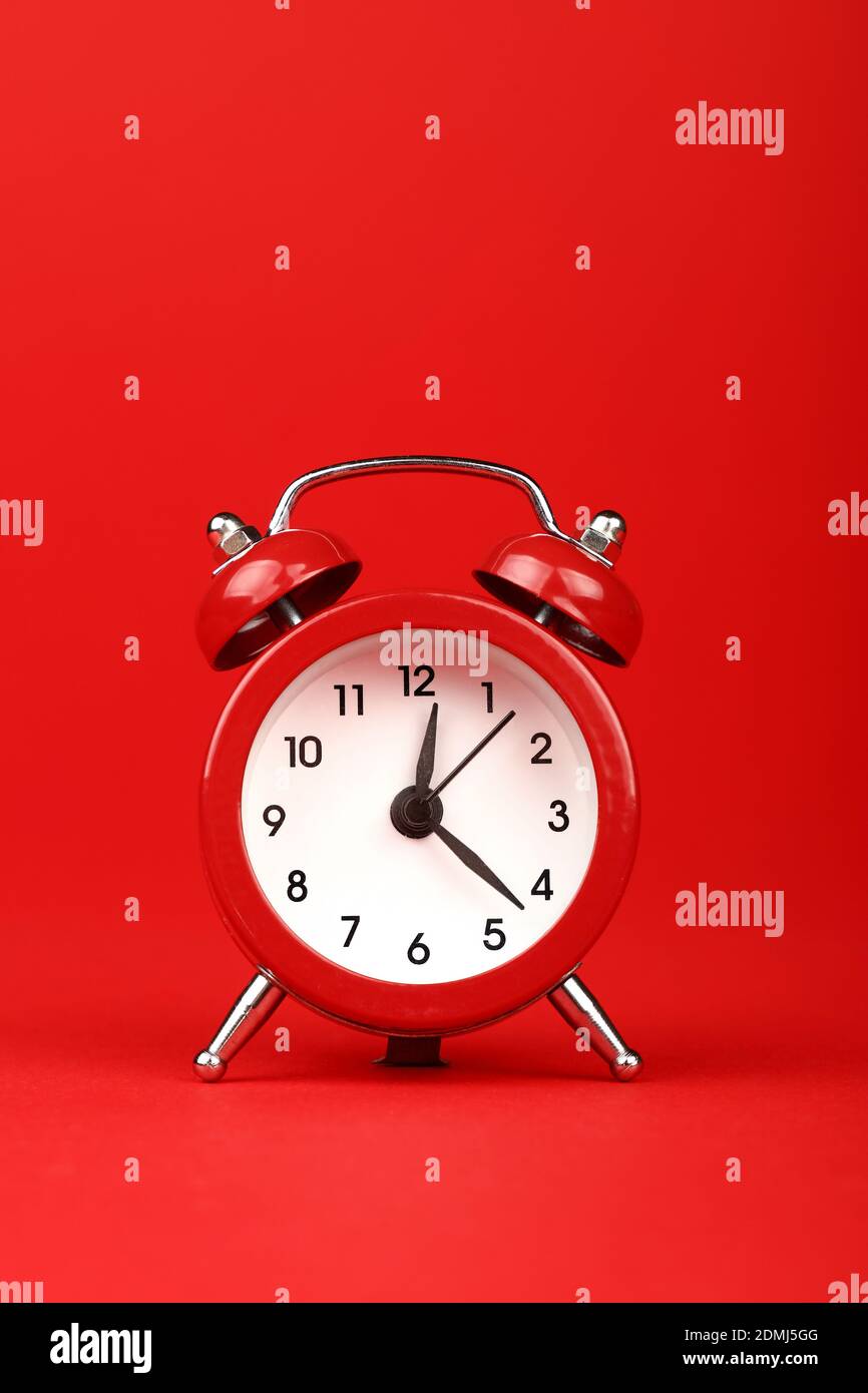 Close-up Of Clock Against Red Background Stock Photo