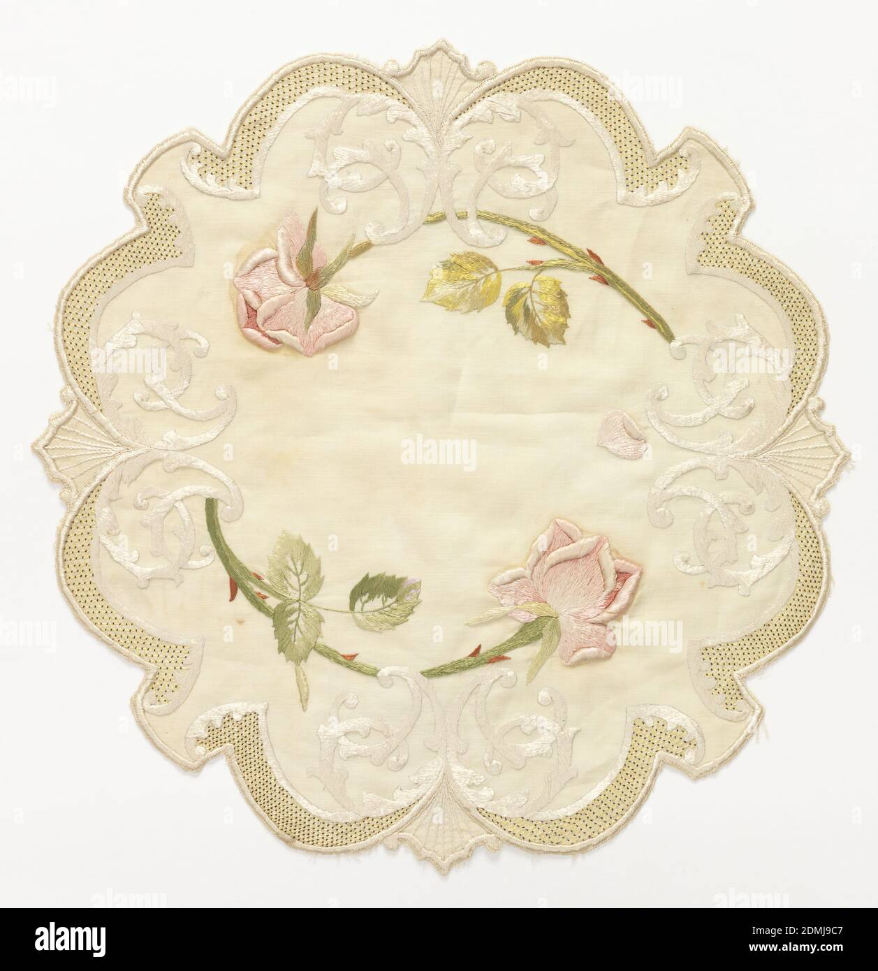 Table mat, Medium: silk embroidery on linen foundation Technique: embroidered using satin stitches on plain weave, Table mat of off-white linen, approximately round with scalloped edges. Embroidered in pale greens, pinks, red and off-white silks with a cipher entwined with two pink roses. Border of small yellow lattice with red dots., USA, late 19th century, embroidery & stitching, Table mat Stock Photo