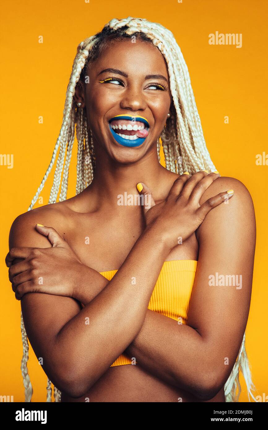 Close up of smiling woman sticking her tongue out and looking away ...