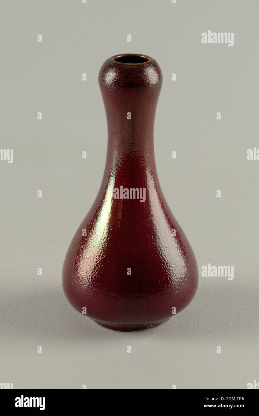 Vase, Dedham Pottery, Earthenware, oxblood, Gray-white stoneware body, thrown. Bulbous body with tapering neck; with slightly bulging area below rim; flat foot. Covered with a deep red or scarlet glaze with slight golden luster effect. Black striations through glaze. Very dark red at rim bulge. Dimpled surface allover. Interior glazed. Bottom not glazed. Glaze very thick at base., Chelsea, Massachusetts, USA, 1884–88, ceramics, Decorative Arts, Vase Stock Photo