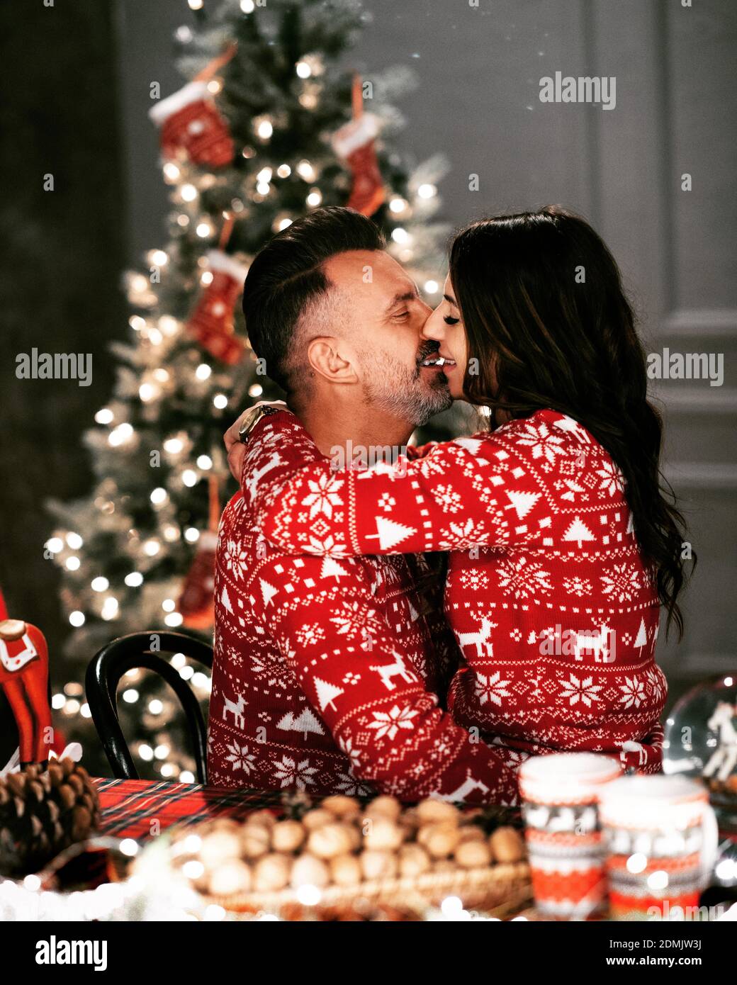 Kissing Couple In Christmas Sweaters On 