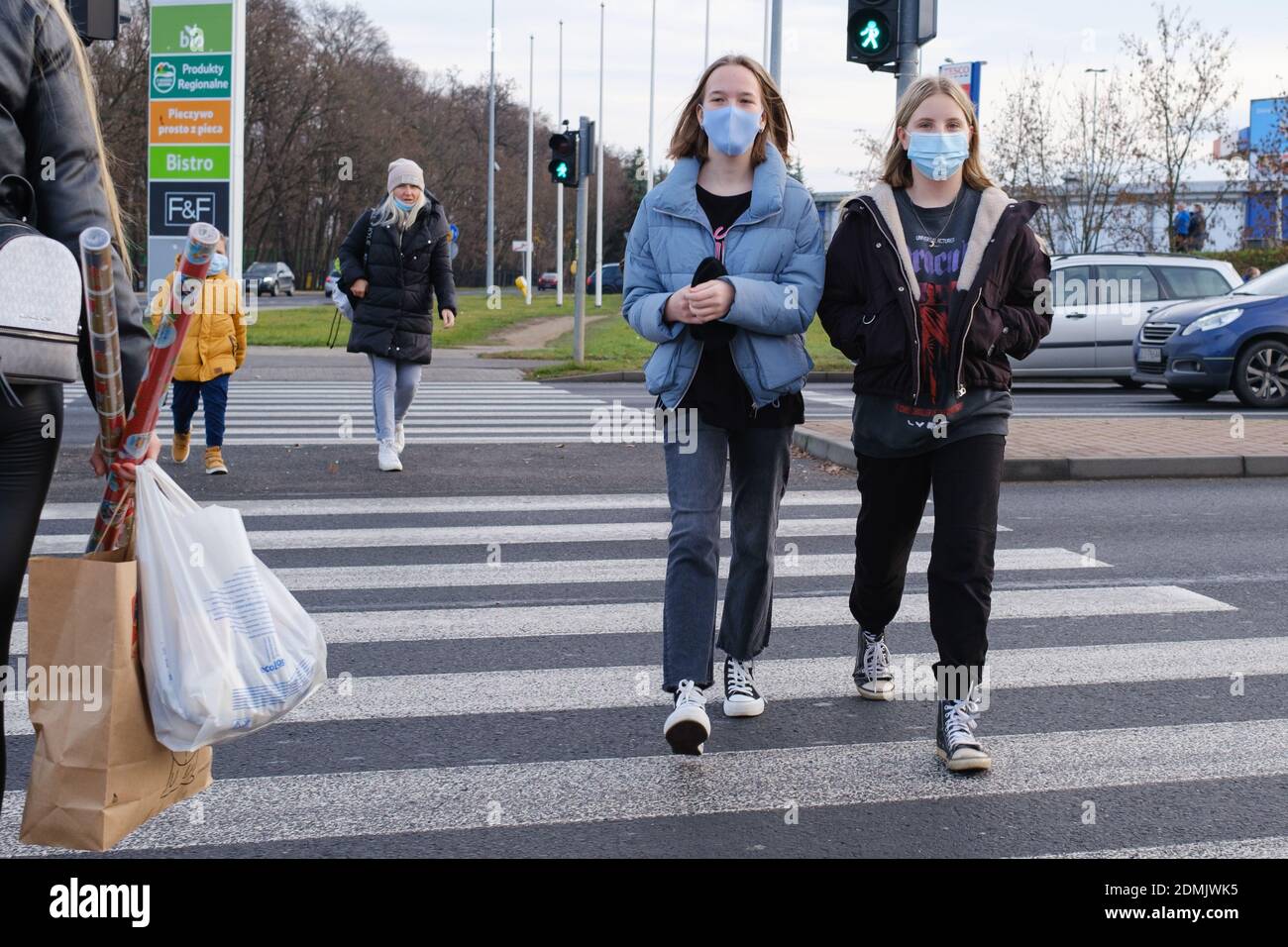 LUBIN, POLAND - DECEMBER 05, 2020. Two teenagers with face masks due to pandemic Covid-19 at the crosswalk. Stock Photo