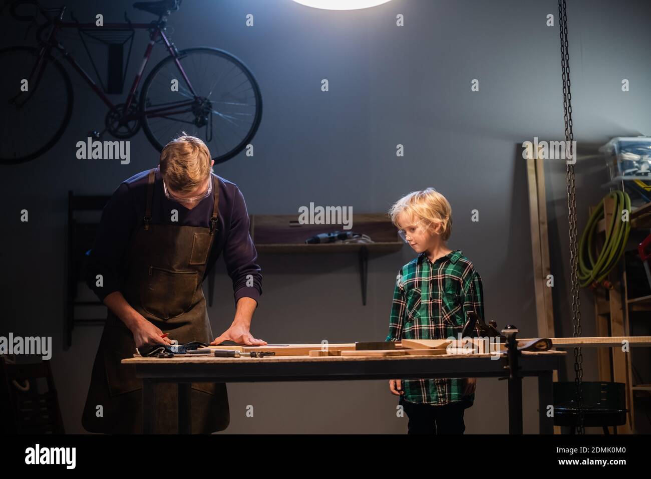 an experienced carpenter and his young apprentice make wood crafts in ...