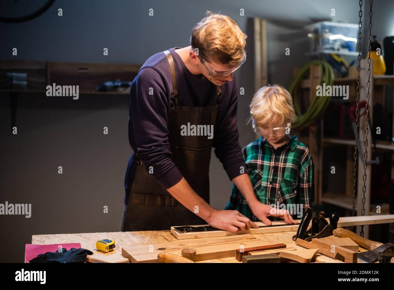 an experienced carpenter and his young apprentice make wood crafts in ...