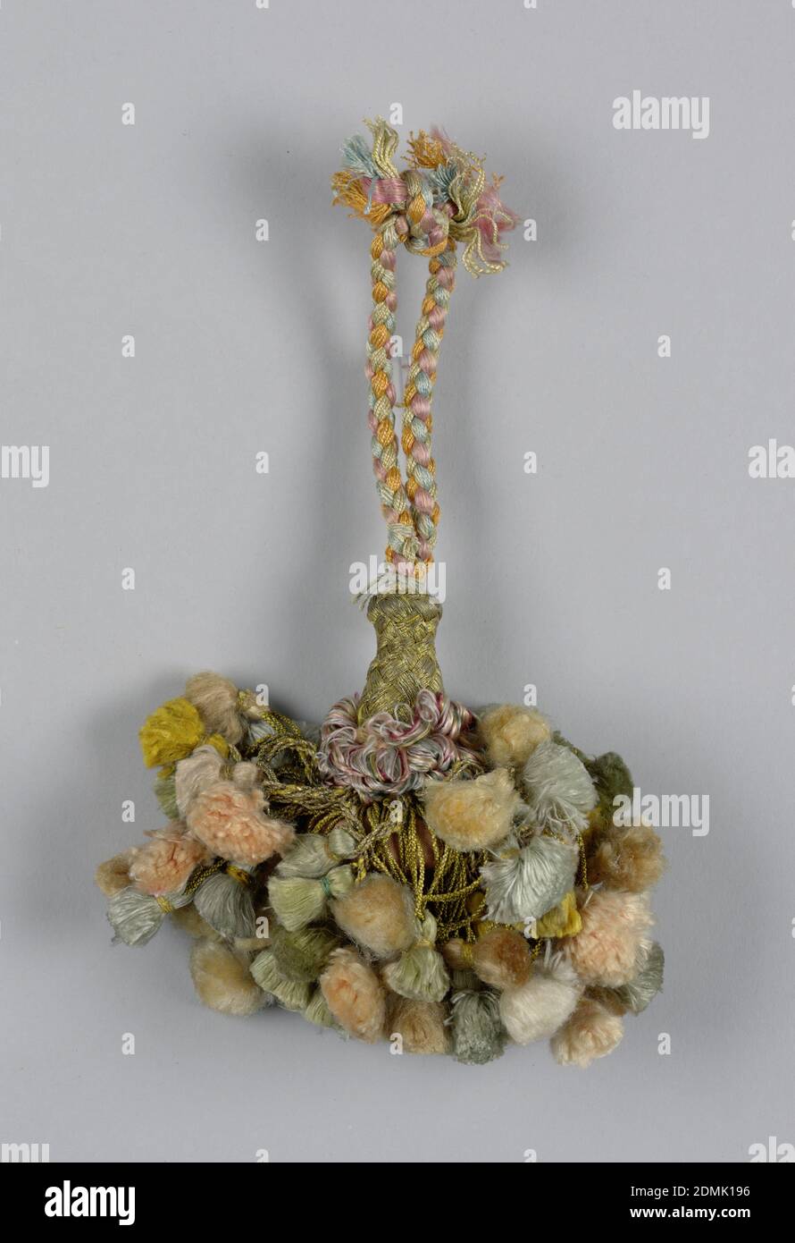 Tassel, Medium: silk, metal threads, wooden core, Skirt of gilt threads, twisted and looped and each supporting a small tassel. Collar of looped and colored silks. Head is vase-shaped and wrapped with gilt threads. Cord of braided pink, blue, yellow, and gold threads., Spain, 18th century, trimmings, Tassel Stock Photo
