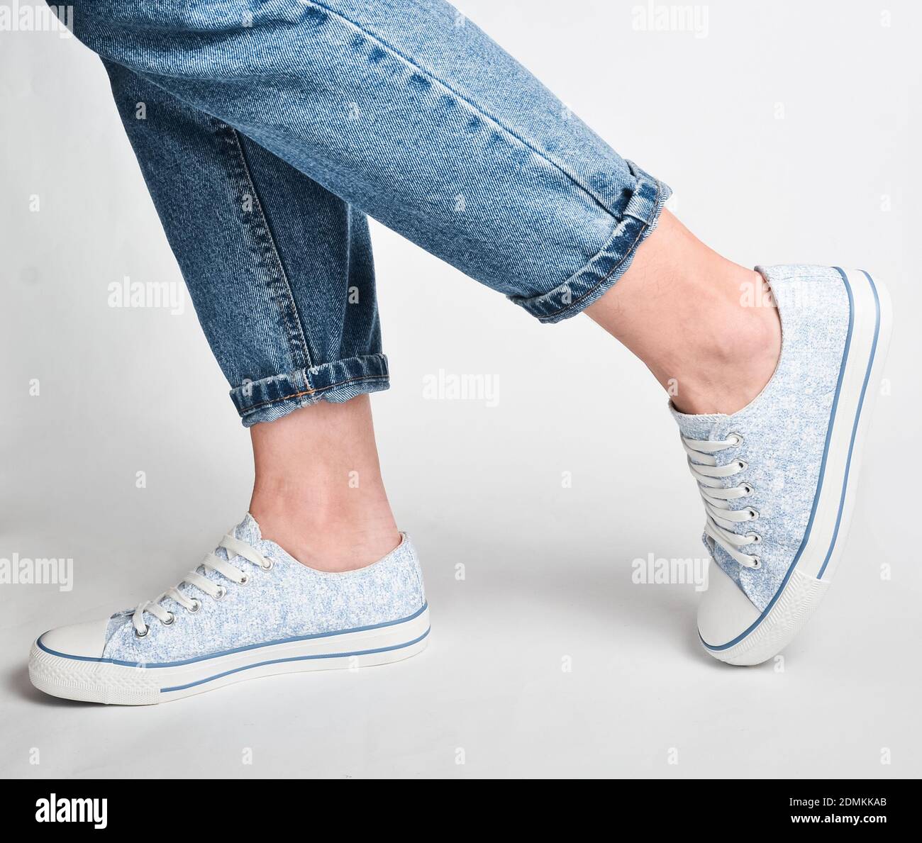 Cropped image of female legs in beige pantyhose and denim jeans standing  straight Stock Photo - Alamy