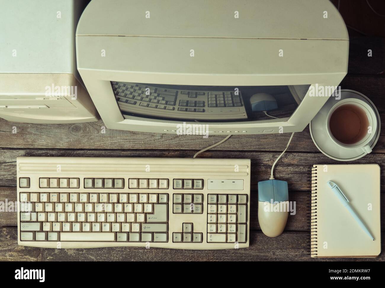 Retro stationary computer on a rustic wooden desk, vintage workspace.  Monitor, keyboard, computer mouse, top view, flat lay Stock Photo - Alamy