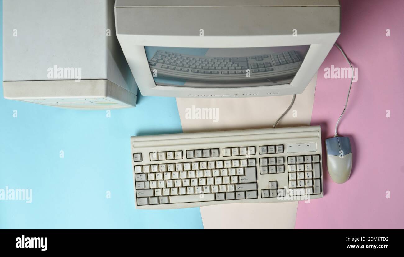 Retro stationary computer on colored background. Monitor, system unit, computer mouse. Obsolete Technologies, top view Stock Photo