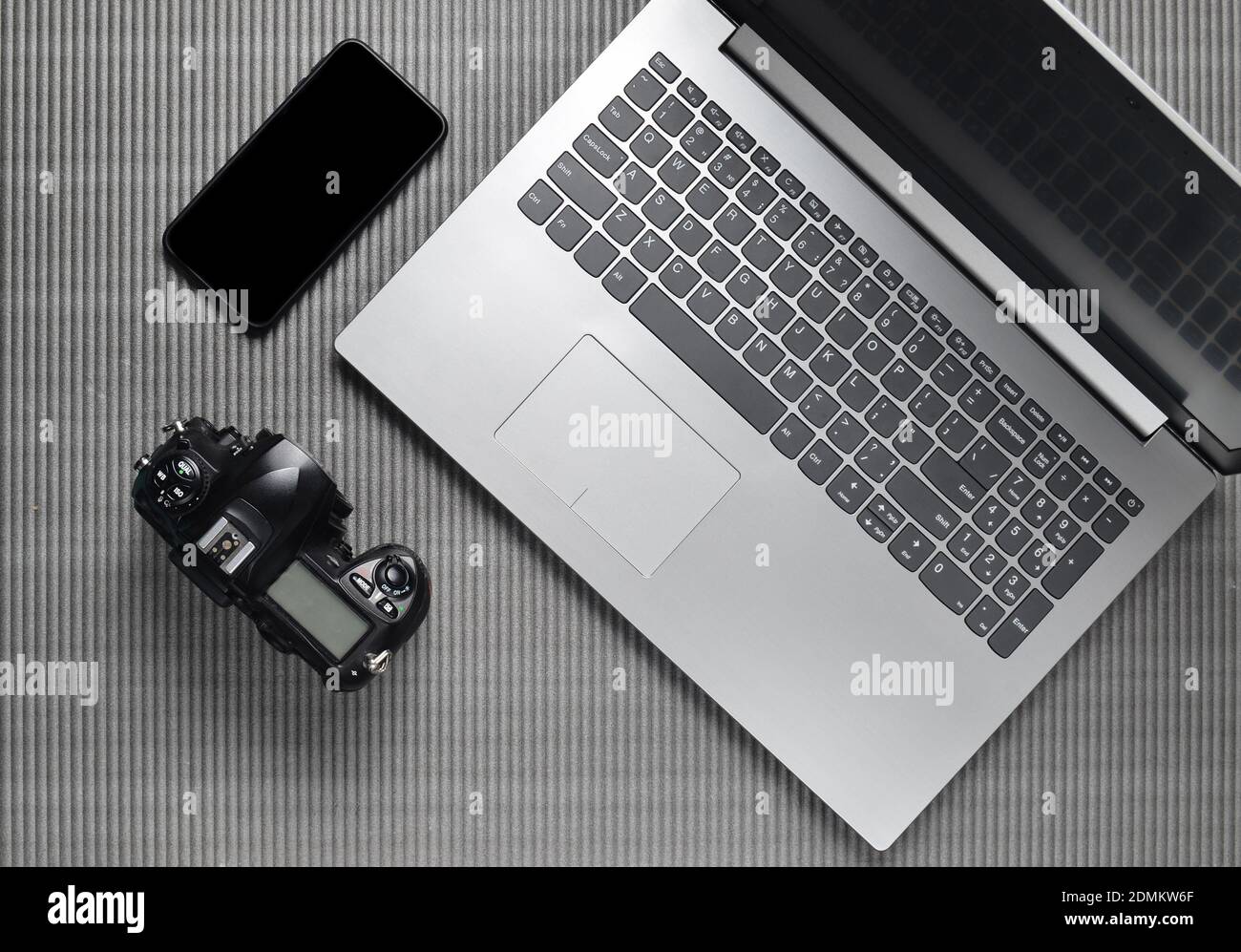 Laptop, frameless phone with white screen, camera on a gray texture surface, top view, copy space Stock Photo