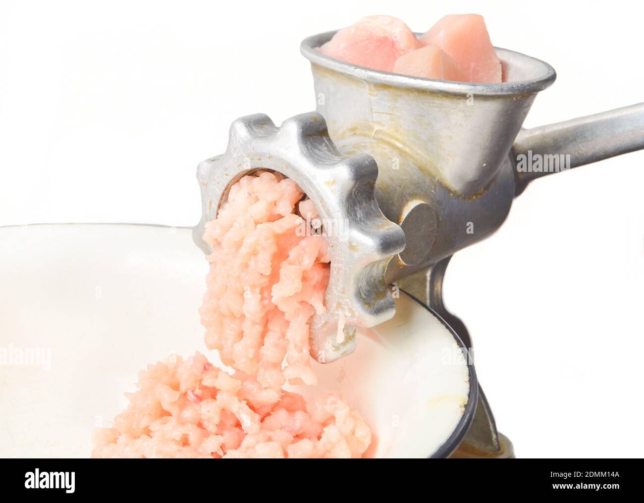 Vintage meat grinder grinds chicken meat isolated on white background