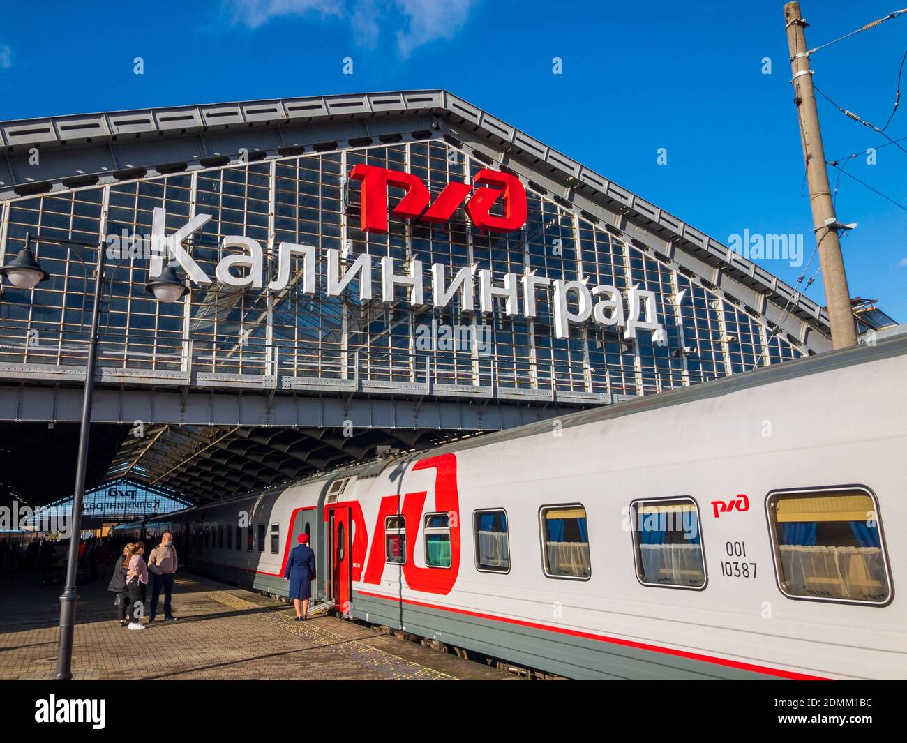 Train on roofed station with passengers Stock Photo