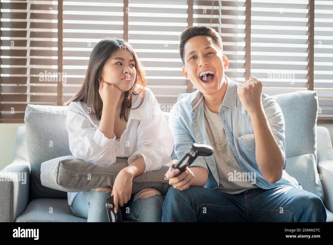 Asian couple lovers enjoy and play console game on vacation make more quality time of happiness together at home Stock Photo
