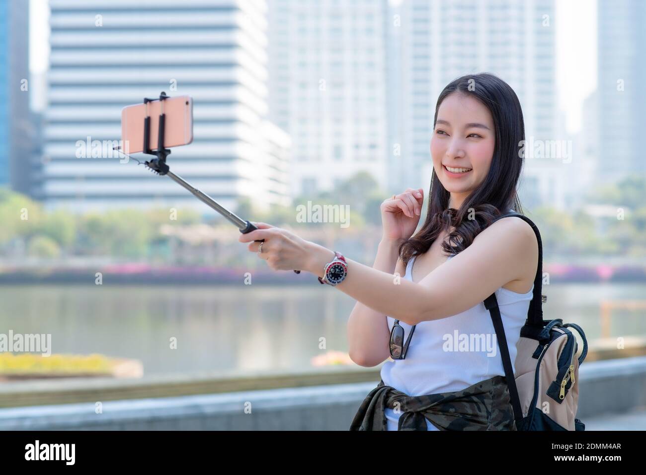 Beautiful asian tourist woman use video call via a smartphone in urban city downtown. Vacation travel in summer. Stock Photo