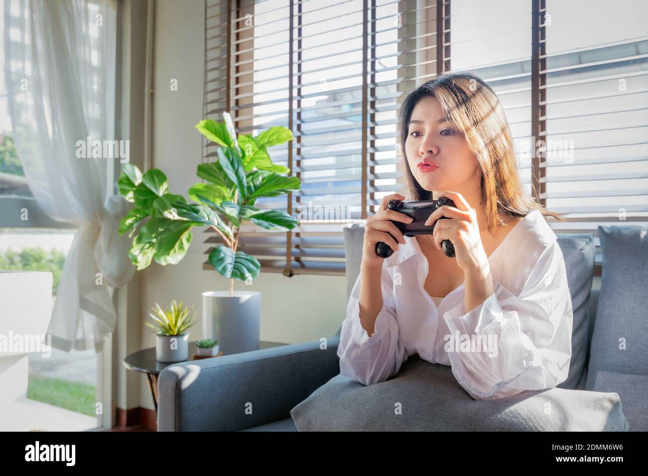 Asian women work from home by casting game streaming online via console game during corona virus or covid19 crisis follow the Social Distancing regula Stock Photo