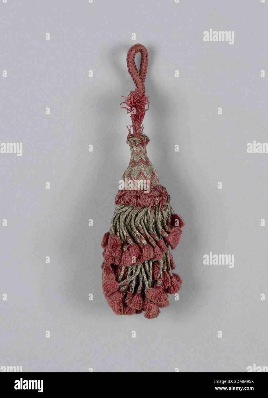 Tassel, Medium: silk, metal thread, wooden core, Skirt of silver threads in two lengths twisted and looped and supporting red silk tassels. Collar of red silk in loops. Head is vase-shaped and wrapped with red silk and silver threads in chevron pattern. Loop of red silk cord., Italy or Spain, 18th century, trimmings, Tassel Stock Photo