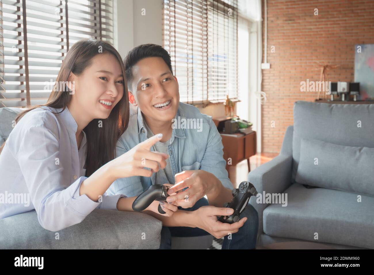 Asian couple lovers enjoy and play console game on vacation make more quality time of happiness together at home Stock Photo