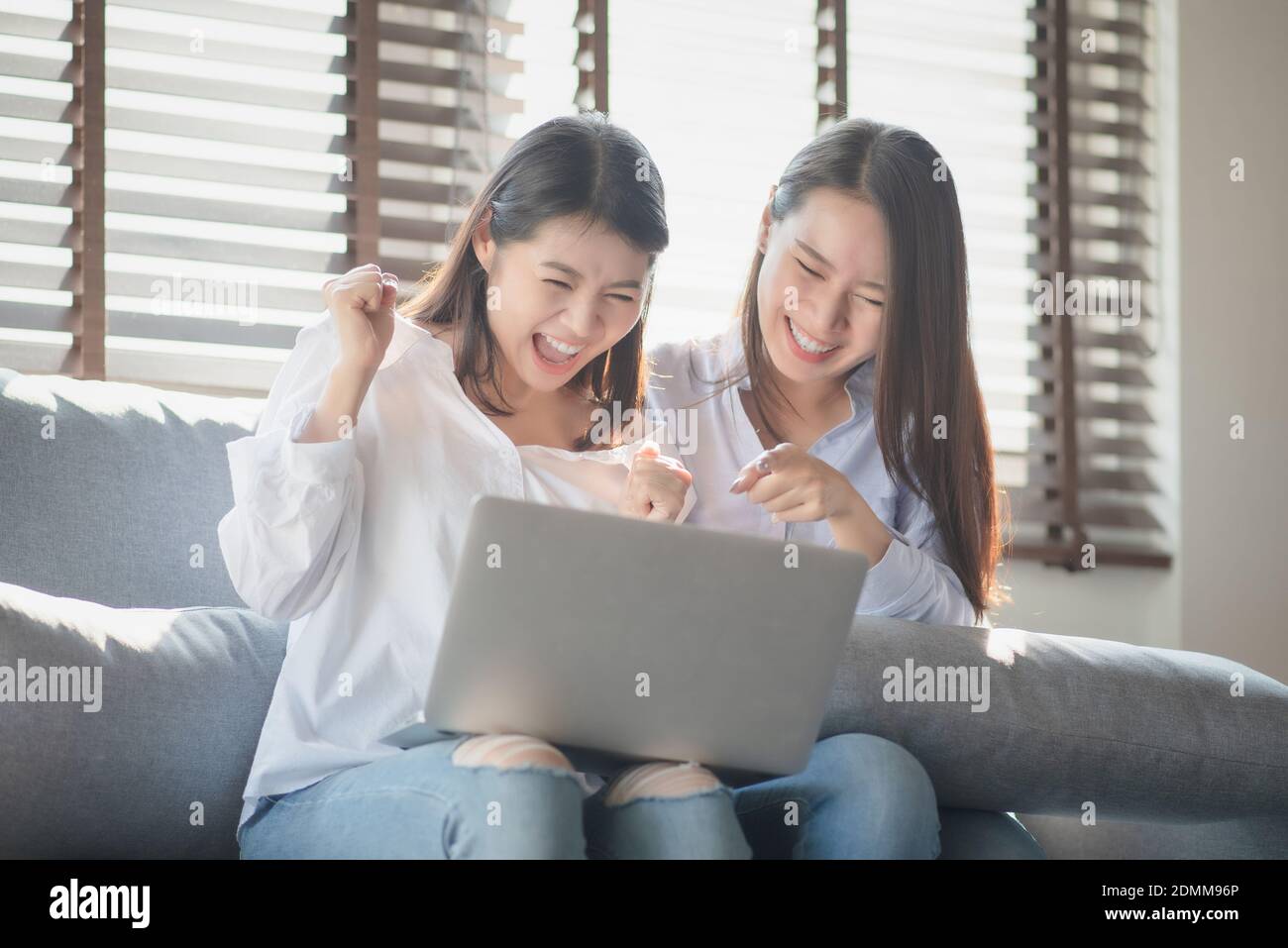 Two young woman use laptop computer to shopping online via internet during stay safe at home Stock Photo