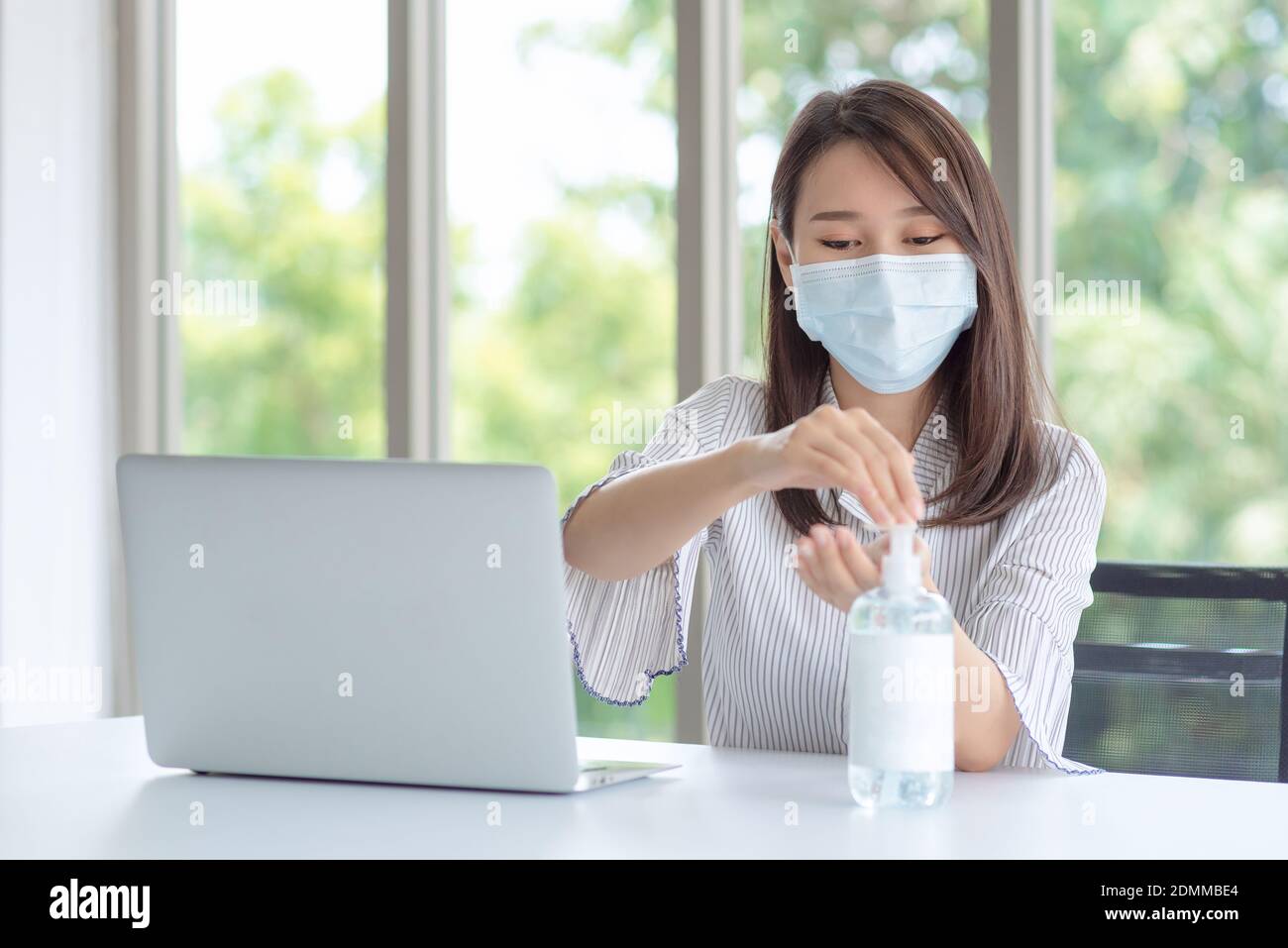 Business woman wearing mask and using personal sanitizer to cleaning her hand in office to keep hygiene.Preventive during the period of epidemic from Stock Photo