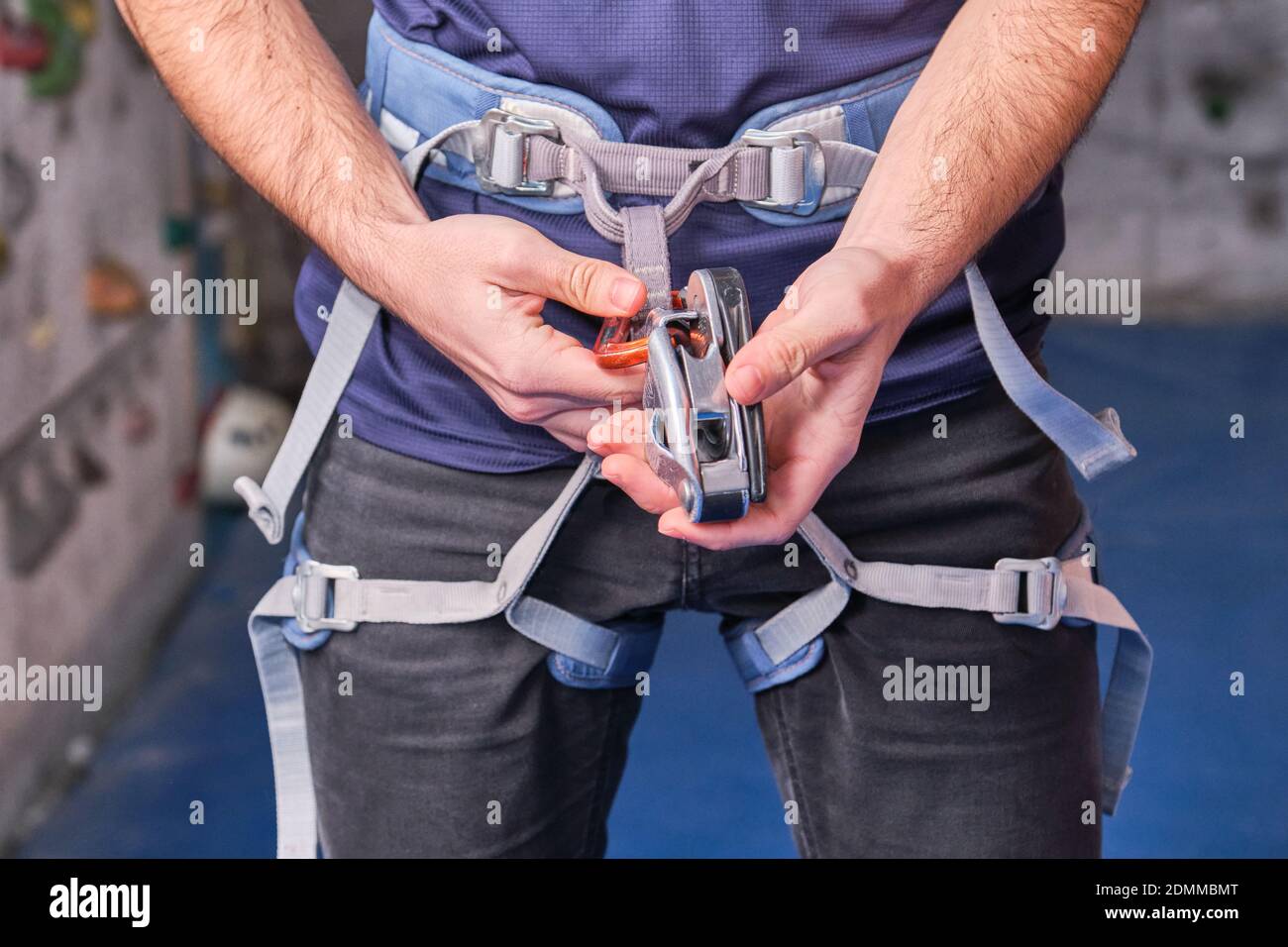 Close-up of climber with climbing equipment, tying snap hook on