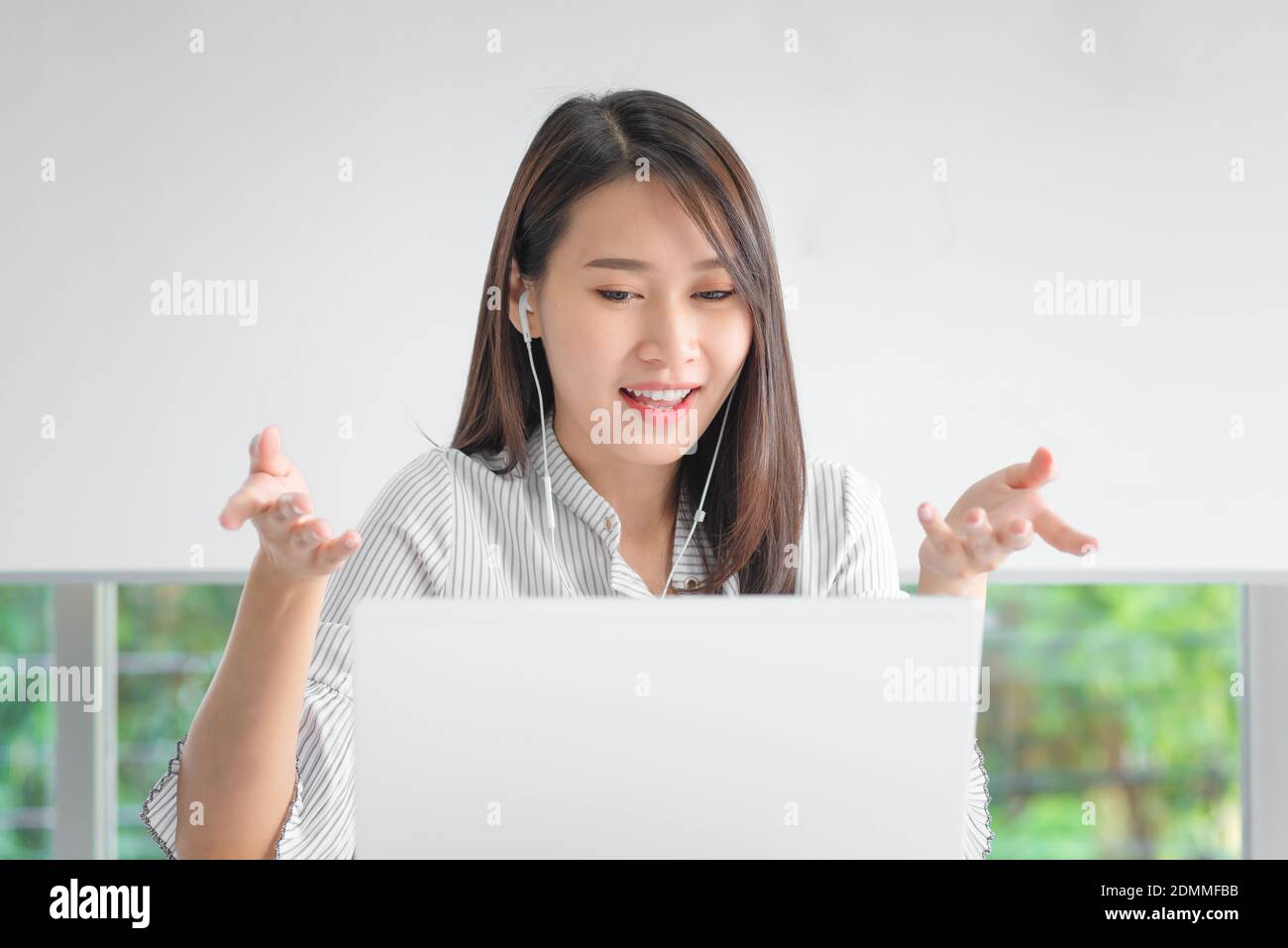 Business employee using laptop for video conferencing with colleagues via internet technology at home office. Stock Photo