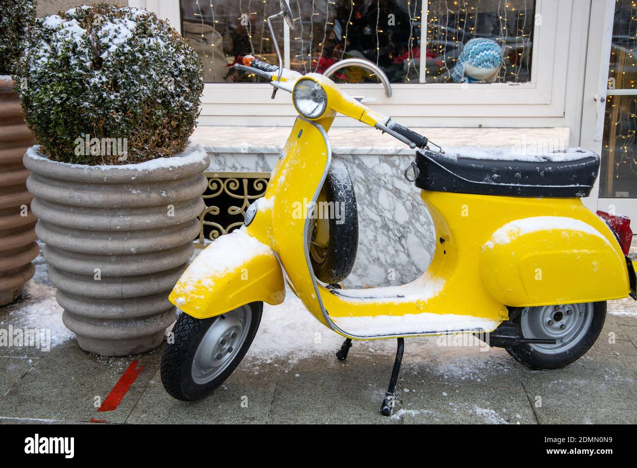 old classic vintage yellow motor scooter covered snow on a winter city ...