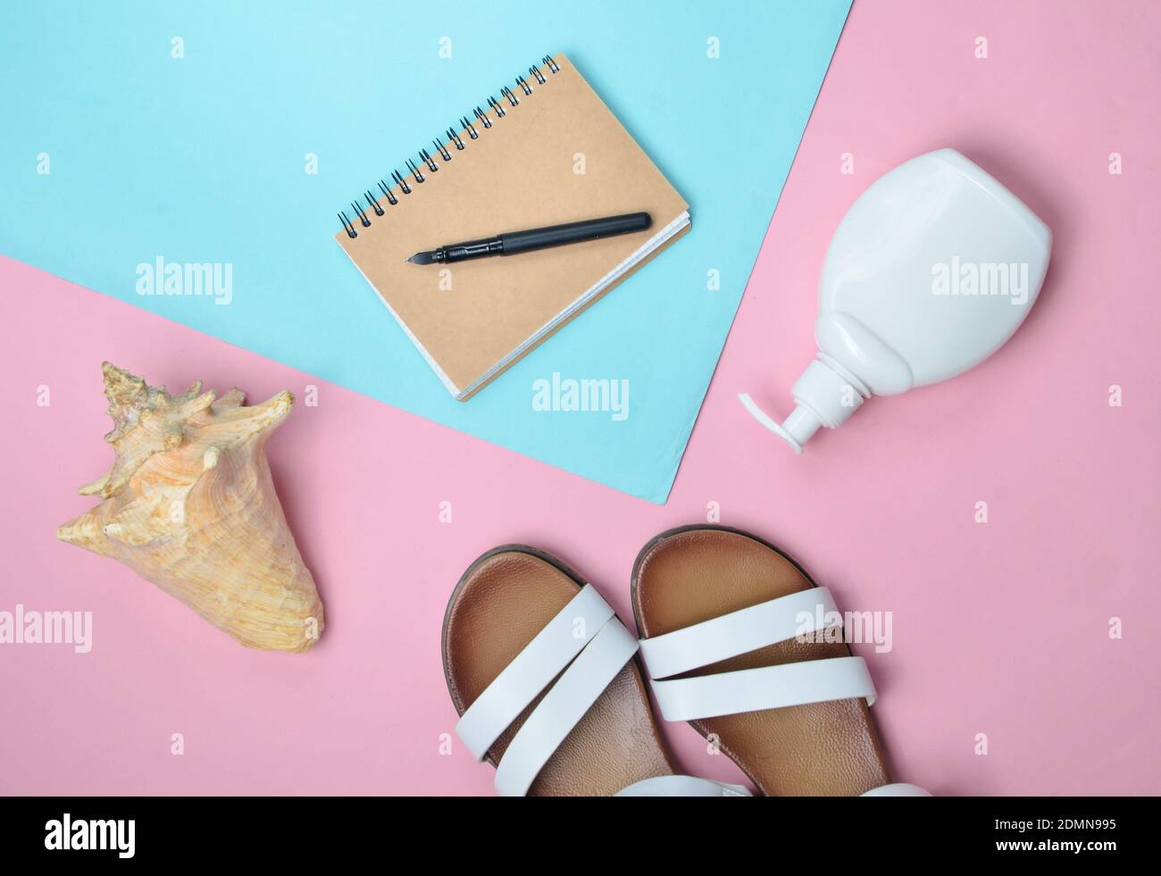 Fashionable leather women's sandals, seashells, sunblock, notepad on colored pastel background, top view, flat lay Stock Photo