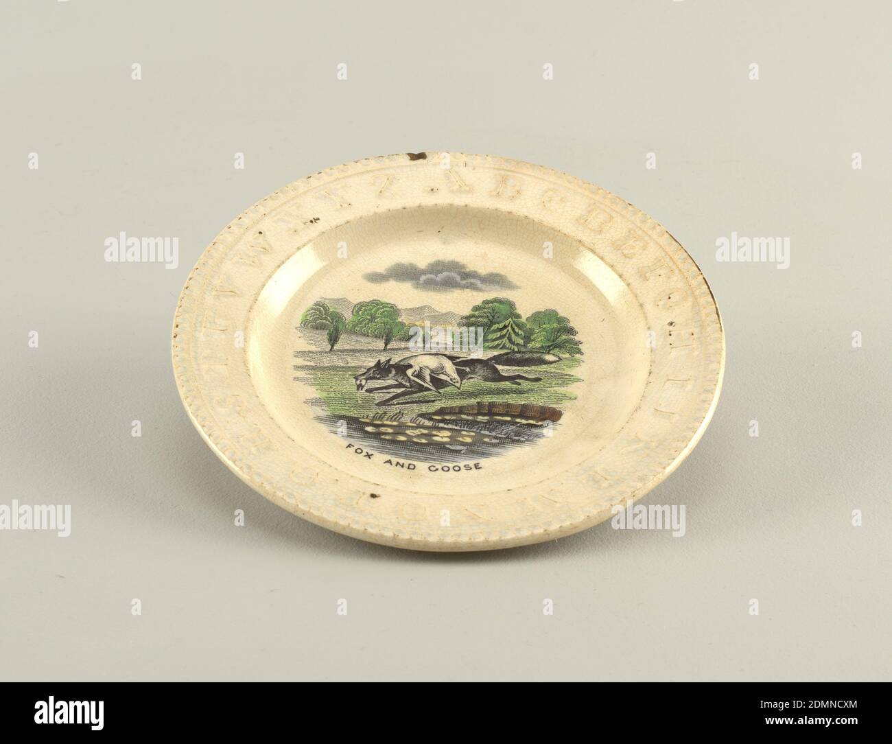 Plate, Creamware with underglaze transfer printing and painting, A and B, with flat marly bearing the alphabet in relief and rope molding on rim. Hand-colored transfer-print of 'Fox and Goose.', USA, late 19th century, ceramics, Decorative Arts, Plate Stock Photo