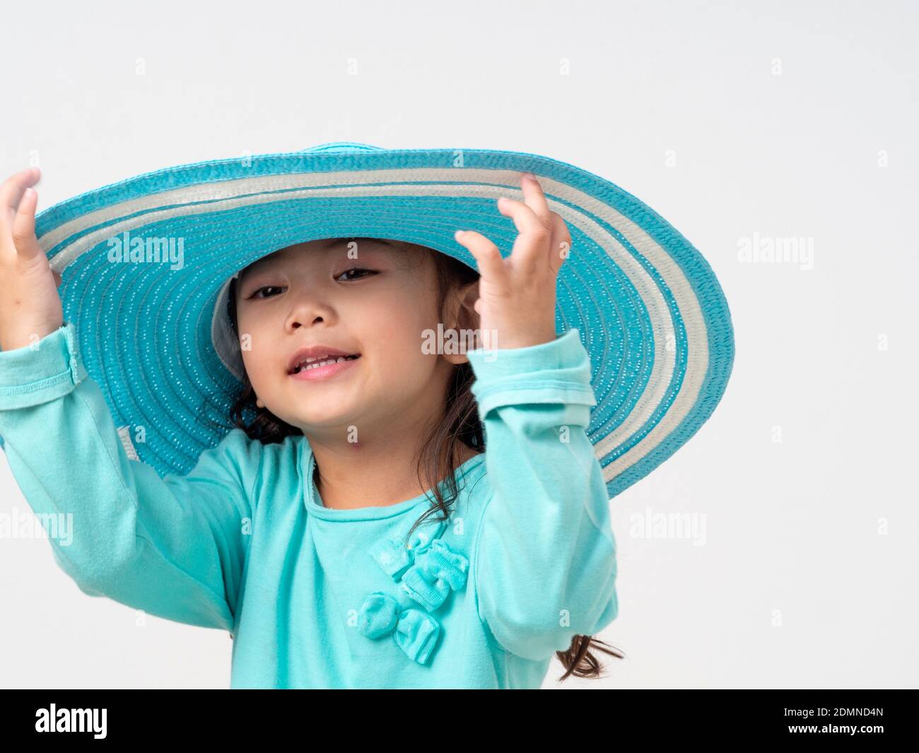 Portrait Of Cute Girl Wearing Blue Hat While Standing Against White