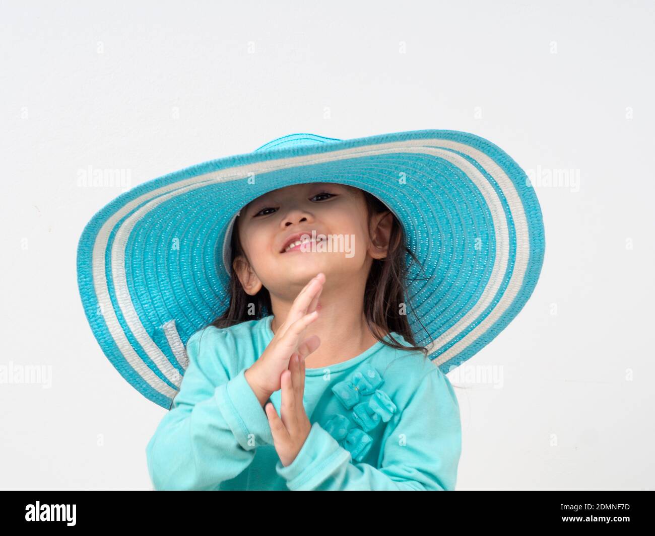 Portrait Of Cute Girl Wearing Blue Hat While Standing Against White