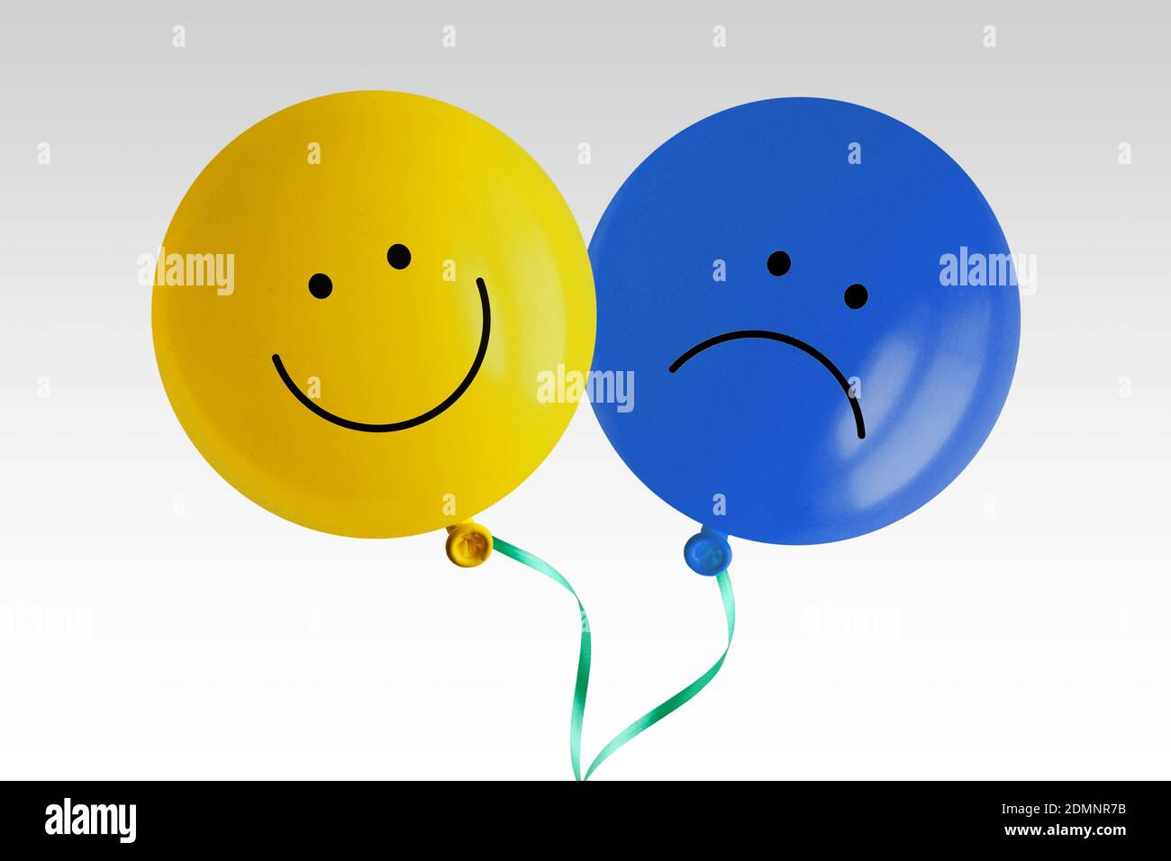 Happy and sad balloon tied together on white background - Concept of bipolar disorder Stock Photo