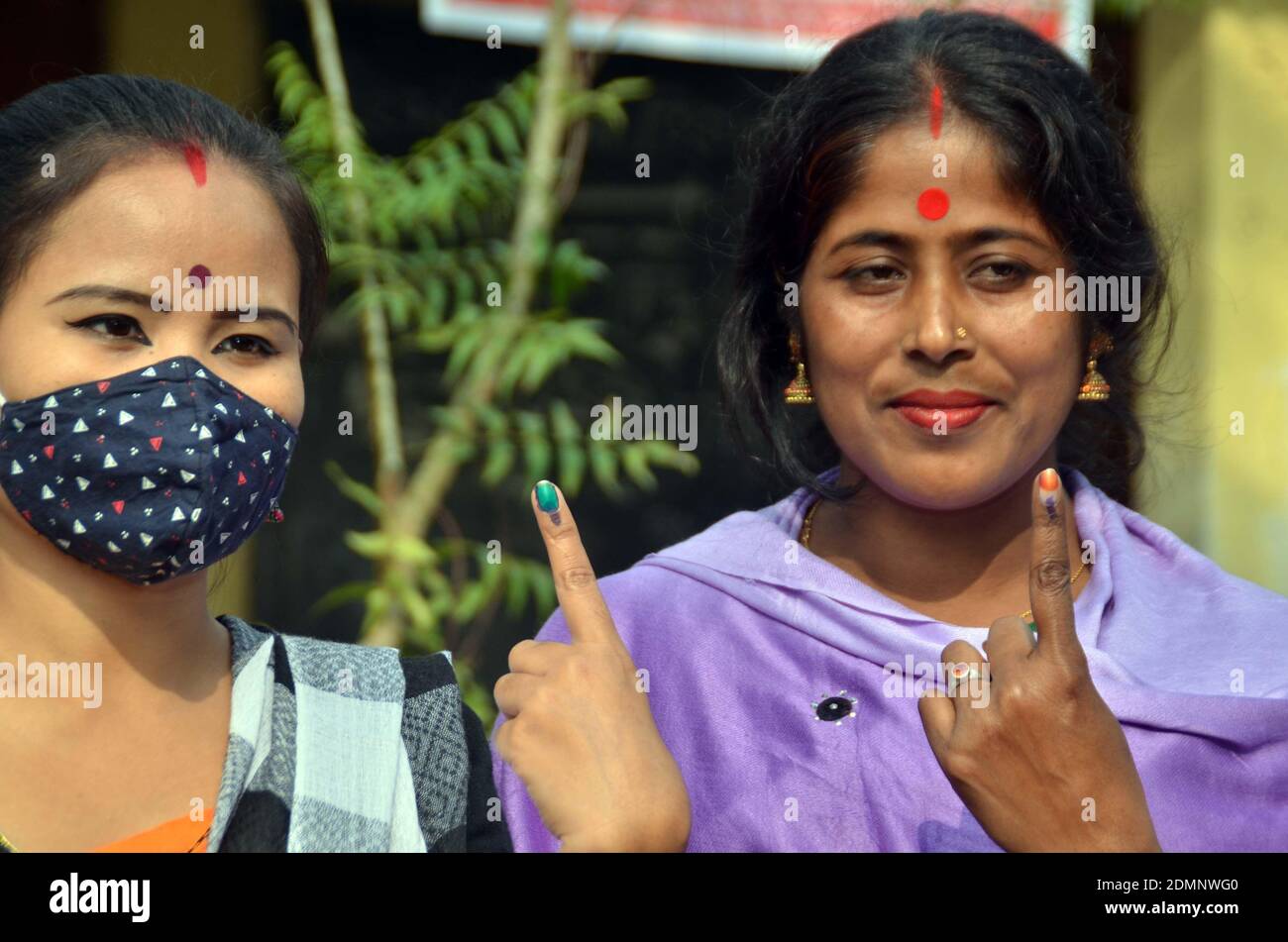 Nagaon, Assam, India - 17  December 2020: Two female voters shows her marks on fingers after casting their votes at a Polling station during the Tiwa Autonomous Council election in Kachamari village in Nagaon district of Assam, India on Thursday.  Credit: DIGANTA TALUKDAR/Alamy Live News Stock Photo