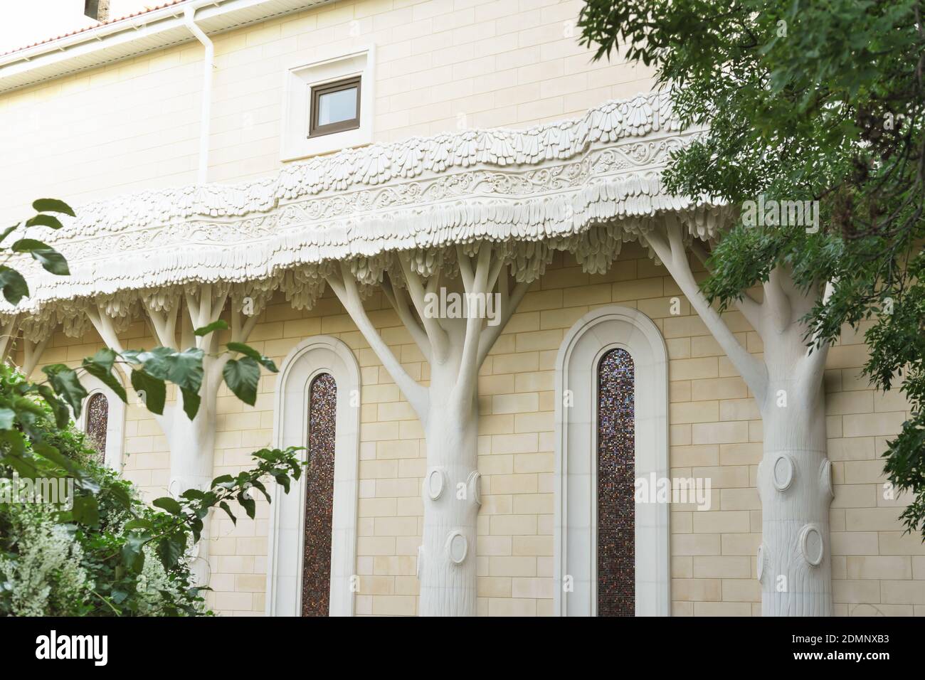 beautiful building with tree shaped pillars. yellow brick house. stained glass windows in oval