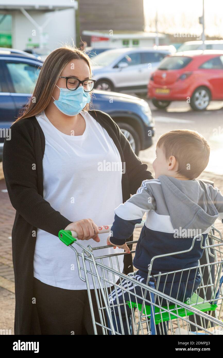 A mother wearing a face mask out shopping with her young child in Fife