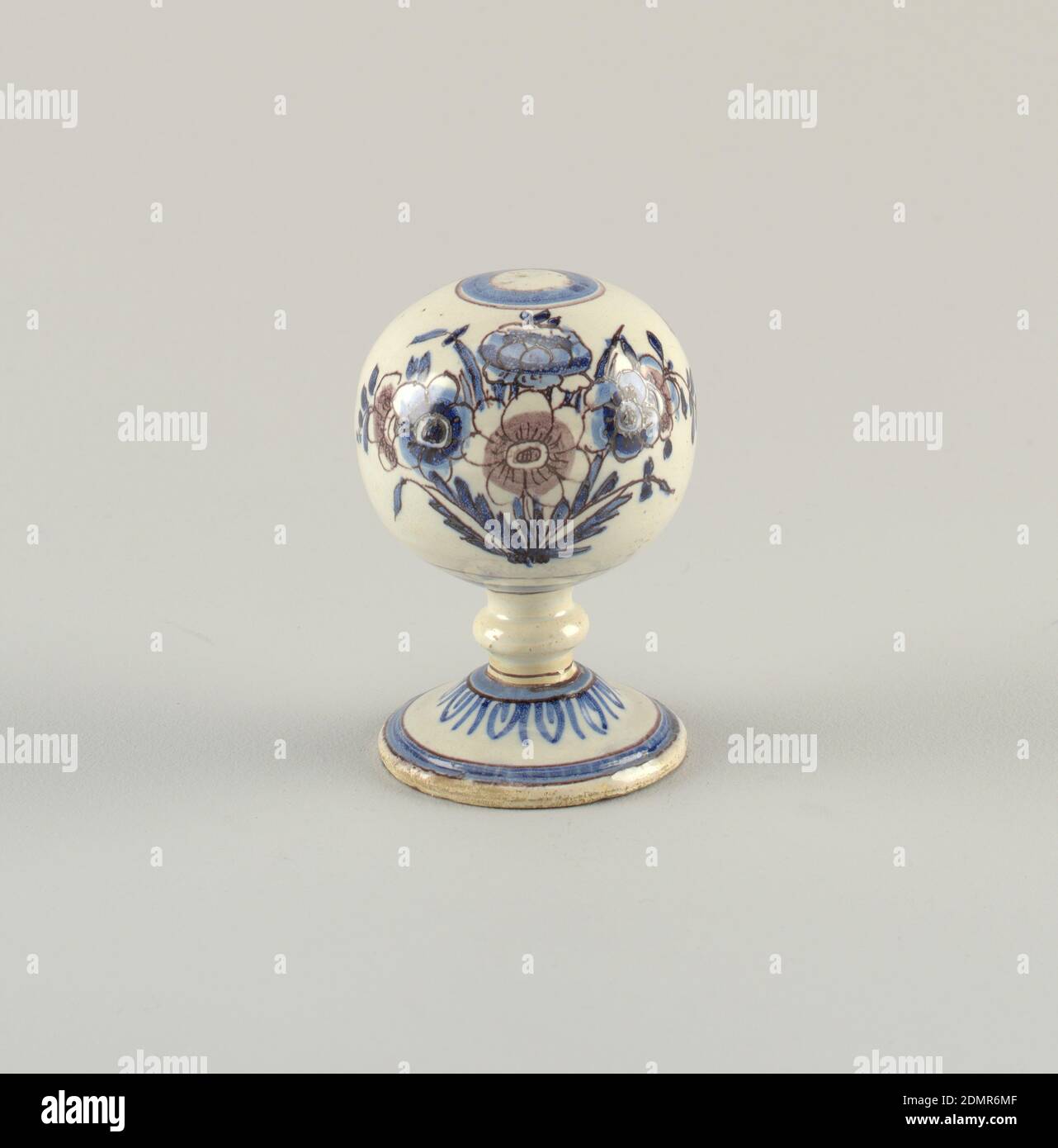 Cap stand, Tin-glazed earthenware, Cobalt blue and manganese purple decoration showing flowers and a bee on globe. Ring of leaves at base of neck. Circles at edge of foot and top of globe., Nevers, France, mid-18th century, ceramics, Decorative Arts, Cap stand Stock Photo