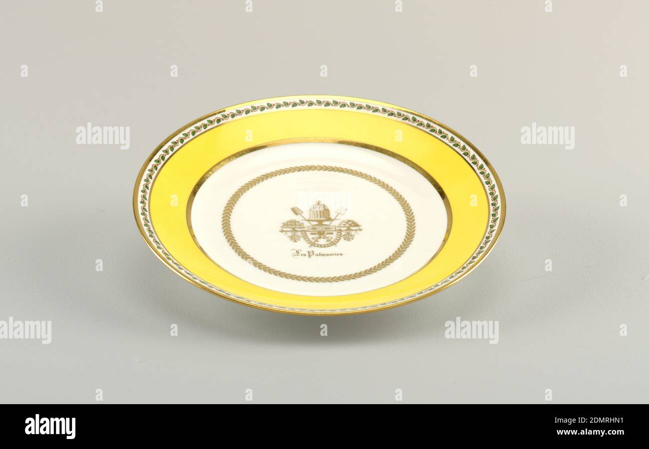 Plate, from the 'Les Patisseries' Service, Sèvres Porcelain Manufactory, French, established 1756 to the present, hard paste porcelain, vitreous enamel, gold, Decorated in yellow, green, red and brown, with gilding. Flat bottom: slightly cavetto marly decorated with concentric bands of yellow and gold, edged with serpentine vine with berries. In bottom, gold laurel wreath enclosing a trophy composed of confections; caption below, in Gothic letters: 'Les Patisseries'., France, 1831, ceramics, Decorative Arts, plate, plate Stock Photo