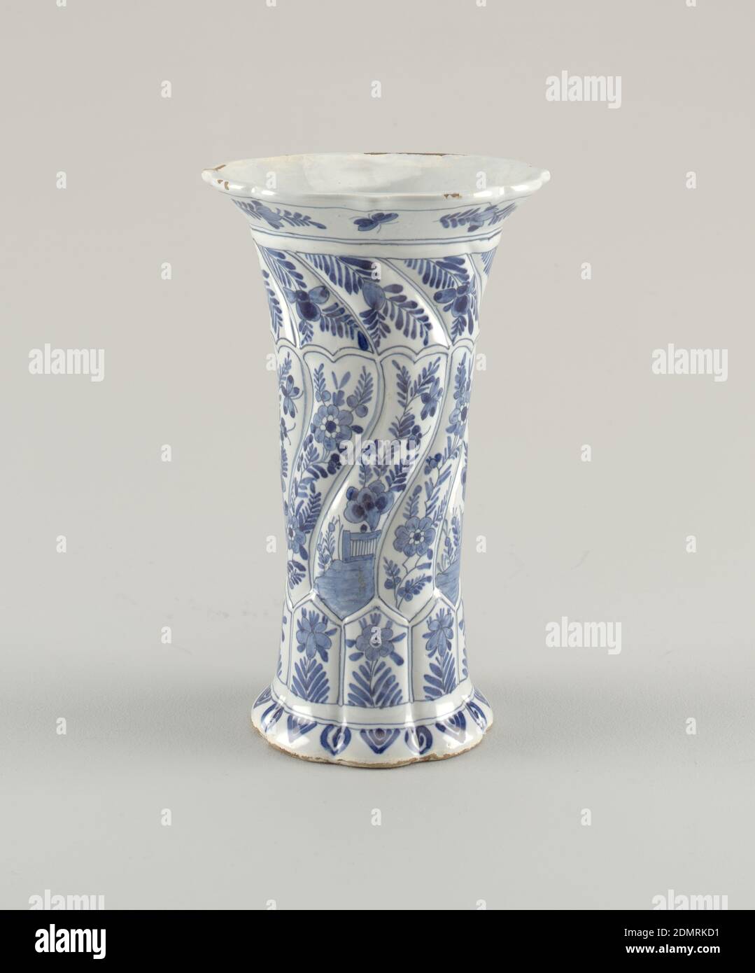 Vase, P V M, Tin-glazed earthenware, Tall, twisted, fluted eight-sided vase with short flared foot and flaring mouth with shaped rim; painted in underglaze blue on white with eight vertical panels each with flower bottom, alternate mid-sections of landscapes or flowers, top section of flowers., Delft, Netherlands, ca. 1800, ceramics, Decorative Arts, Vase Stock Photo