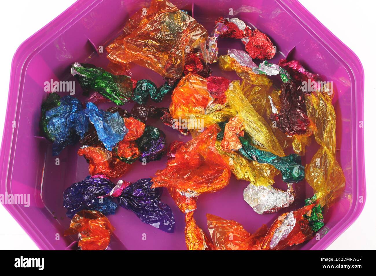 A tub of empty sweet wrappers, binge eating concept Stock Photo